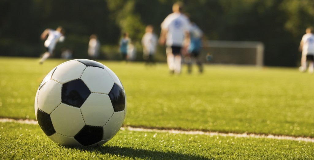 bildet viser en fotball i fokus av en kamp